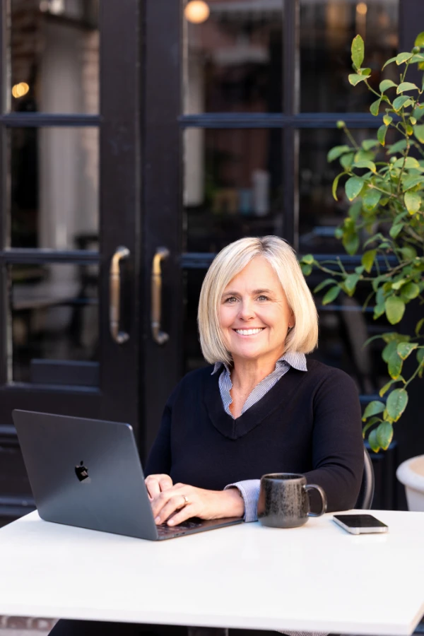 Cecilia Dahl working on a laptop at an outdoor table